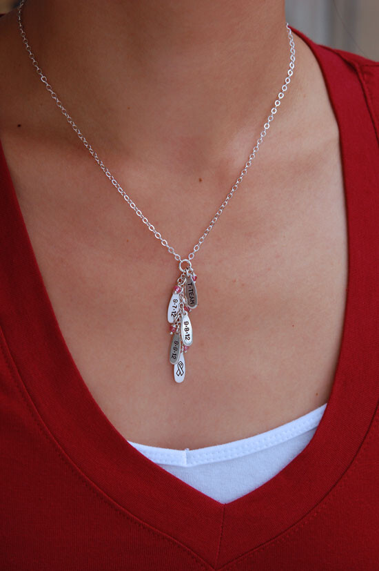 Woman wearing cascade necklace with silver charms and birthstones. From Heart On Your Wrist