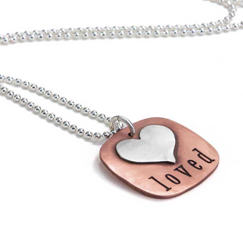 Choose the word you want on yours Copper Square with a silver heart on it, with the word Loved , shown from the side. From Heart On Your Wrist