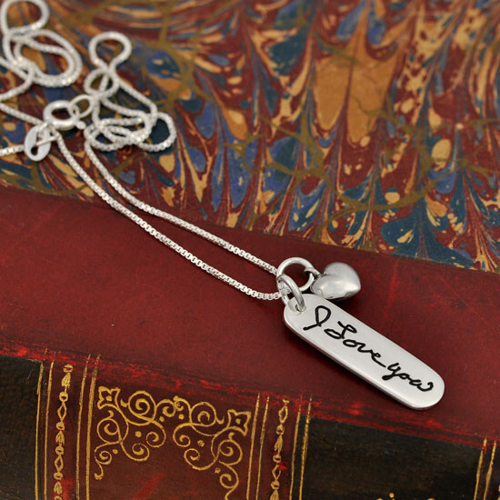 Silver handwriting tag with "I Love You" Silver handwriting tag with "I Love You" shown on a book